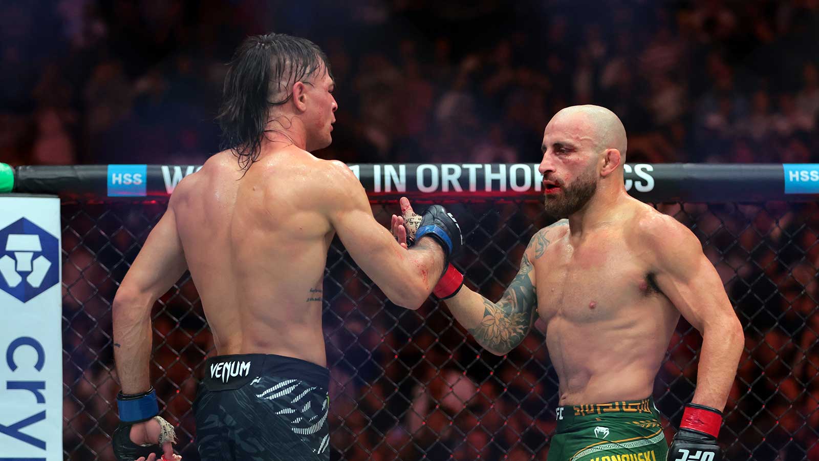 Alexander Volkanovski (red gloves) shake hands with Diego Lopes (blue gloves) during UFC 314 at Kaseya Center.