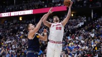 Houston Rockets center Alperen Sengun (28) shoots the ball past Denver Nuggets center Nikola Jokic (15) in the second quarter at Ball Arena.