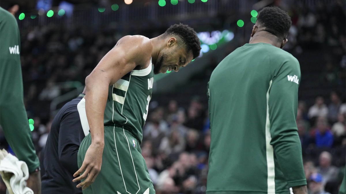 Milwaukee Bucks forward Giannis Antetokounmpo (34) grimaces as he limps off the court after going down with an injury in the first half against the Detroit Pistons at Fiserv Forum.