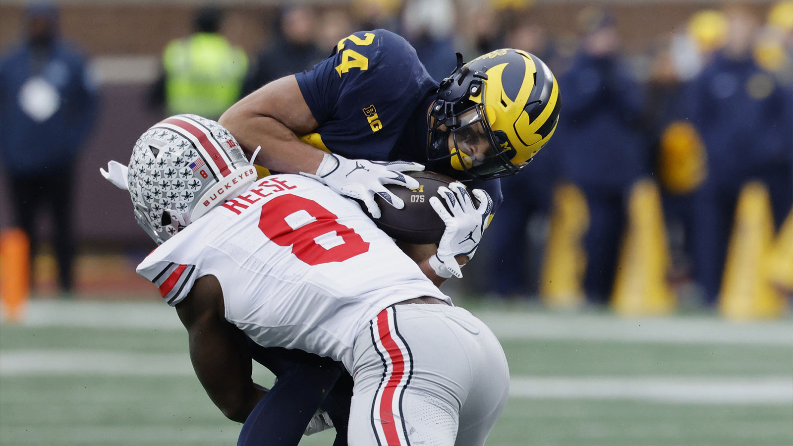 Michigan Wolverines running back Bryson Kuzdzal (24) is tackled by Ohio State Buckeyes linebacker Arvell Reese (8) at Michigan Stadium.