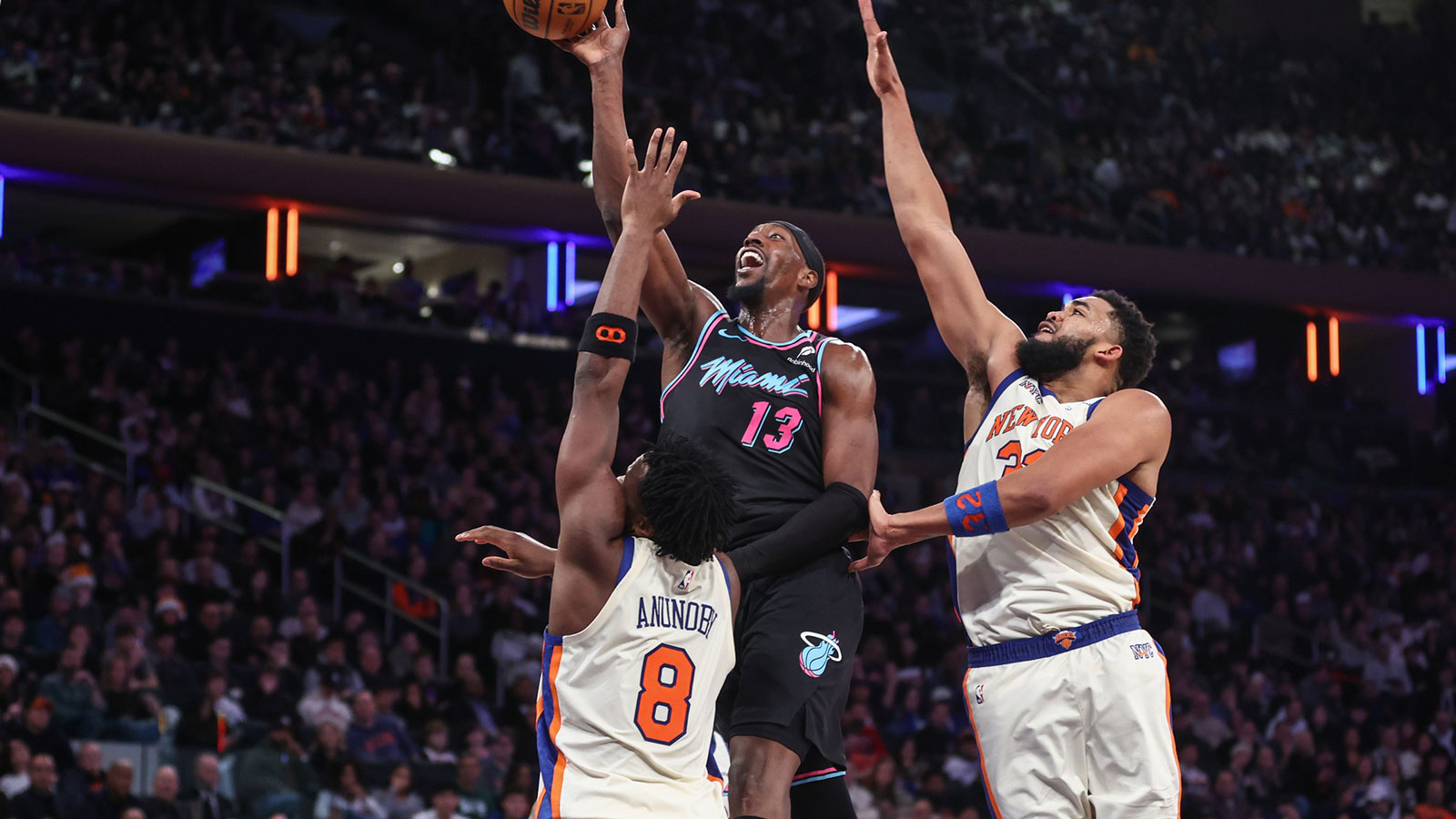 Miami Heat center Bam Adebayo (13) drives past New York Knicks forward Og Anunoby (8) and New York Knicks center Karl-Anthony Towns (32) in the fourth quarter at Madison Square Garden.