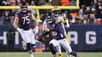 Chicago Bears quarterback Caleb Williams (18) runs with the ball and offensive tackle Ozzy Trapilo (75) watches the play against Green Bay Packers defensive end Brenton Cox Jr. (57) during overtime at Soldier Field.