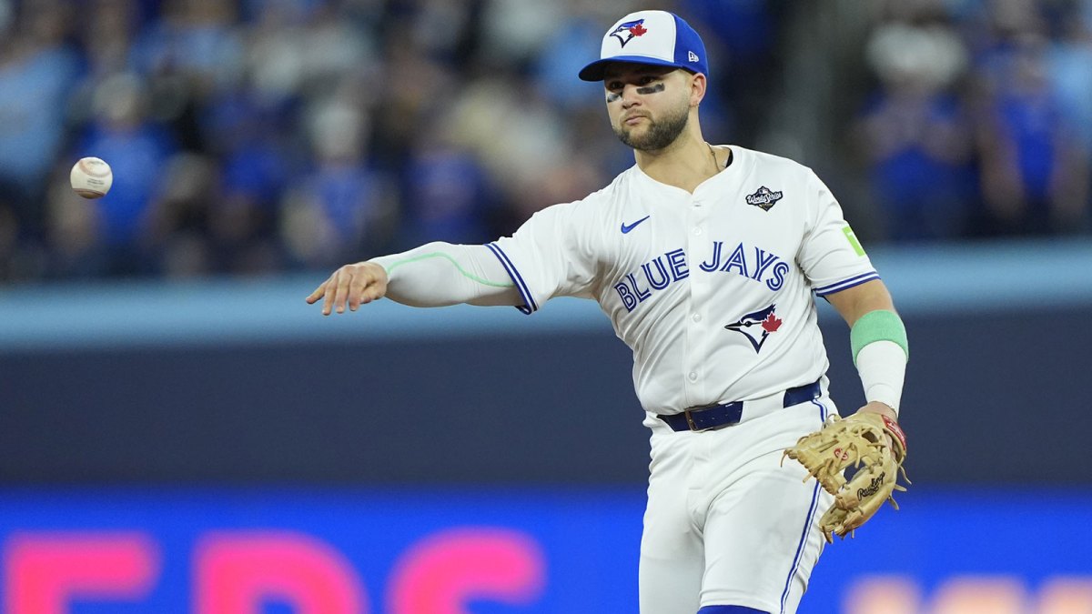 Toronto Blue Jays designated hitter Bo Bichette (11) throws to first for an out against Los Angeles Dodgers second baseman Tommy Edman (25) in the eighth inning during game seven of the 2025 MLB World Series at Rogers Centre.