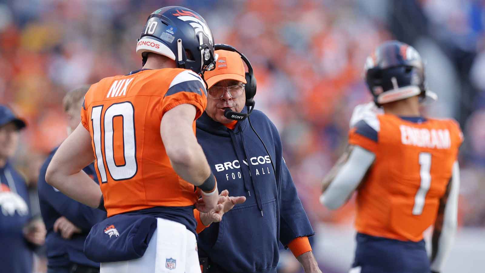 Denver Broncos head coach Sean Payton talks with quarterback Bo Nix (10) during the second quarter against the Green Bay Packers at Empower Field at Mile High.