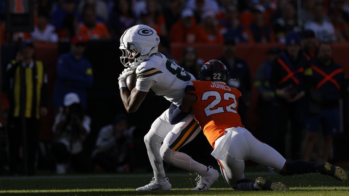 Green Bay Packers wide receiver Savion Williams (83) runs for a gain past Denver Broncos safety Brandon Jones (22) during the first quarter at Empower Field at Mile High.