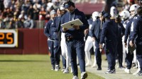 Dallas Cowboys head coach Brian Schottenheimer (center) looks on from the sidelines against the Washington Commanders during the first half at Northwest Stadium
