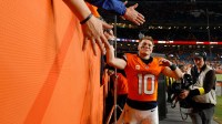 Denver Broncos quarterback Bo Nix (10) high-fives fans following a win over the Green Bay Packers at Empower Field at Mile High.