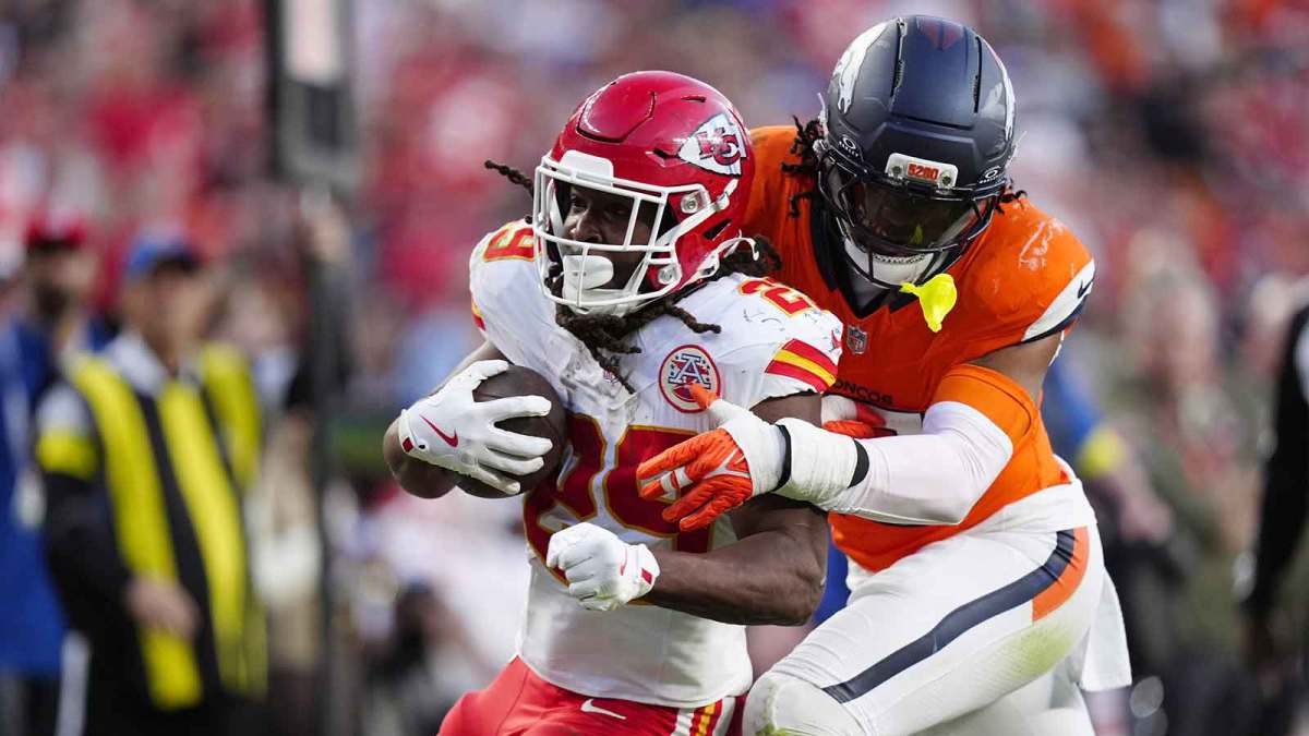 Denver Broncos linebacker Nik Bonitto (15) tackles Kansas City Chiefs running back Kareem Hunt (29) carries the ball in the third quarter at Empower Field at Mile High.