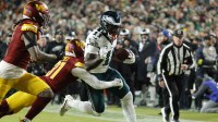 Philadelphia Eagles wide receiver A.J. Brown (11) carries the ball as Washington Commanders cornerback Jonathan Jones (31) and Washington Commanders linebacker Frankie Luvu (4) defend during the first half at Northwest Stadium