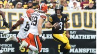 Cleveland Browns defensive end Myles Garrett (95) and linebacker Carson Schwesinger (49) chase Pittsburgh Steelers quarterback Aaron Rodgers (8) during the second quarter at Acrisure Stadium.