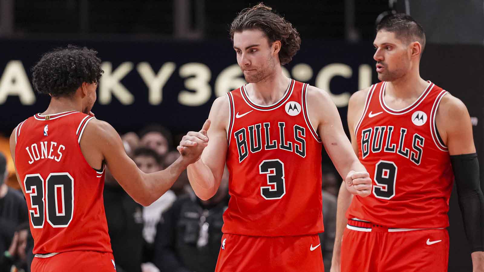 Bulls guard Tre Jones (30) guard Josh Giddey (3) and center Nikola Vucevic (9) react after defeating the Atlanta Hawks at State Farm Arena