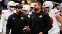 Ohio State Buckeyes offensive coordinator Brian Hartline and head coach Ryan Day leads warm ups during the NCAA football game against the Michigan Wolverines at Michigan Stadium in Ann Arbor, Mich. on Nov. 29, 2025. Ohio State won 27-9.