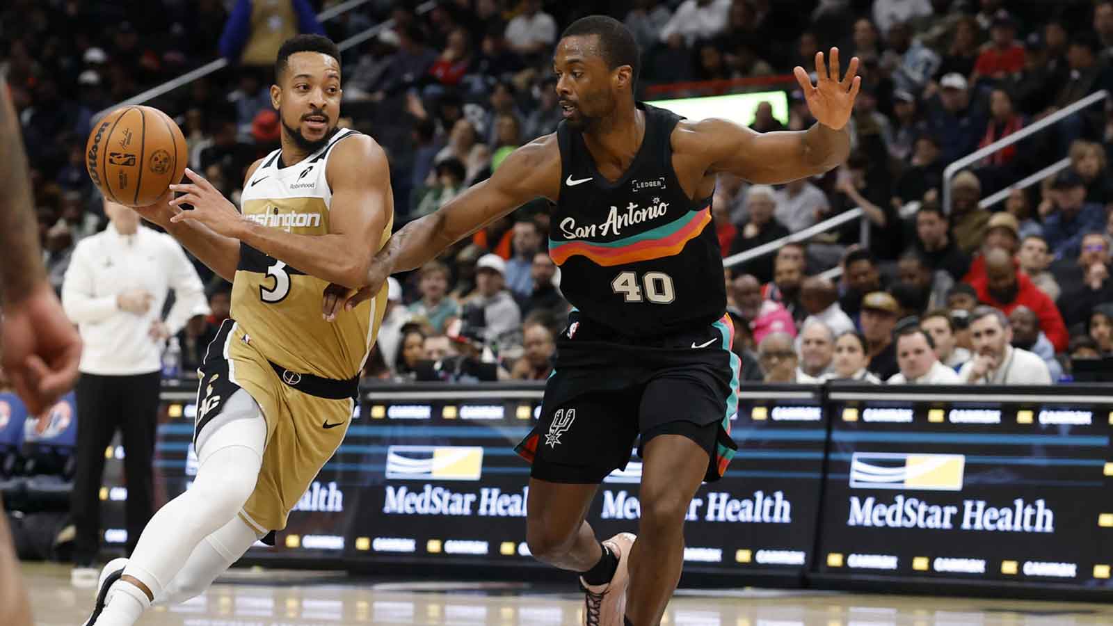 Washington Wizards guard CJ McCollum (3) drives to the basket as San Antonio Spurs forward Harrison Barnes (40) defends in the second half at Capital One Arena.