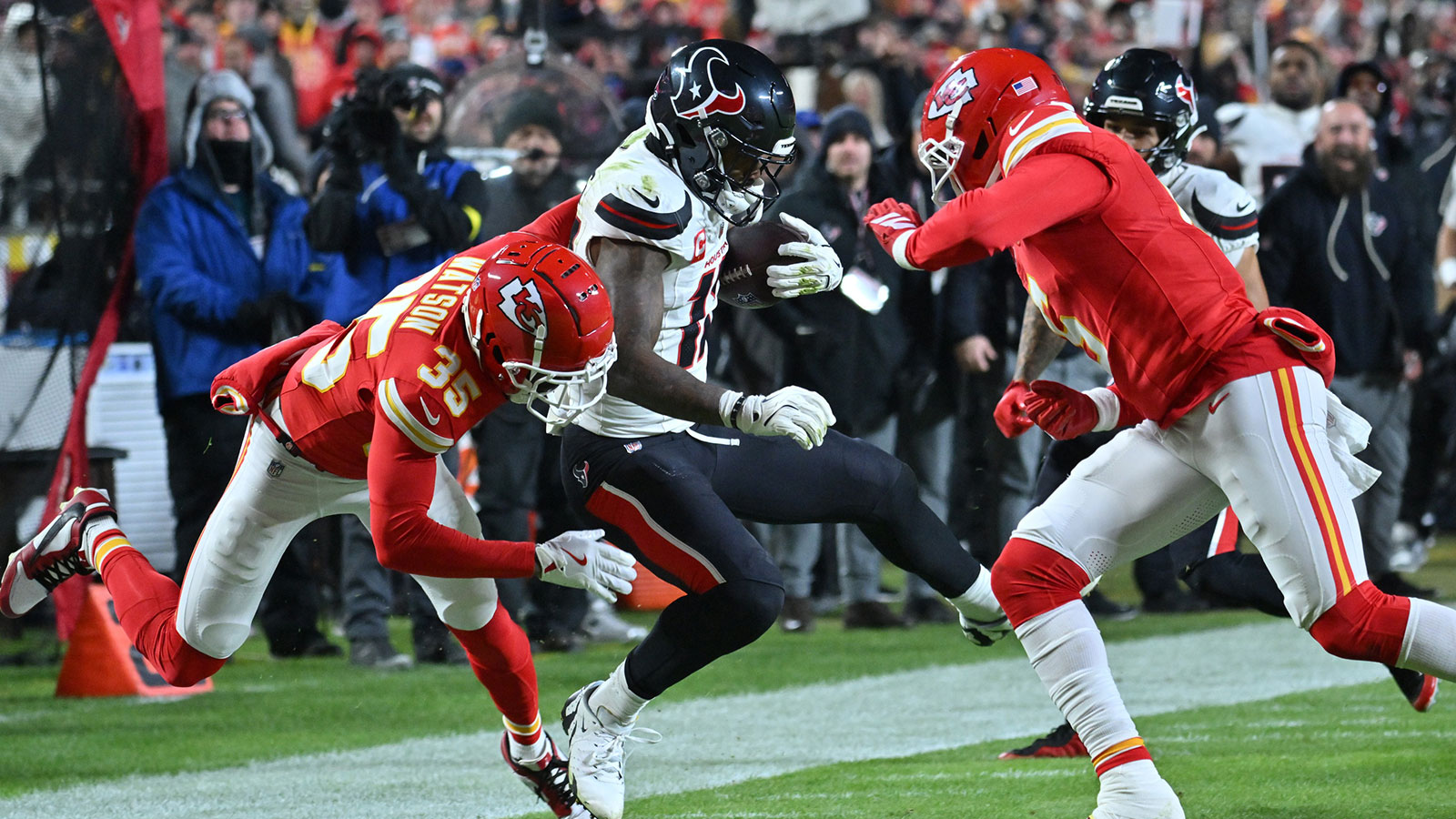 Houston Texans wide receiver Nico Collins (12) is tackled by Kansas City Chiefs cornerback Jaylen Watson (35) during the second quarter at GEHA Field at Arrowhead Stadium.