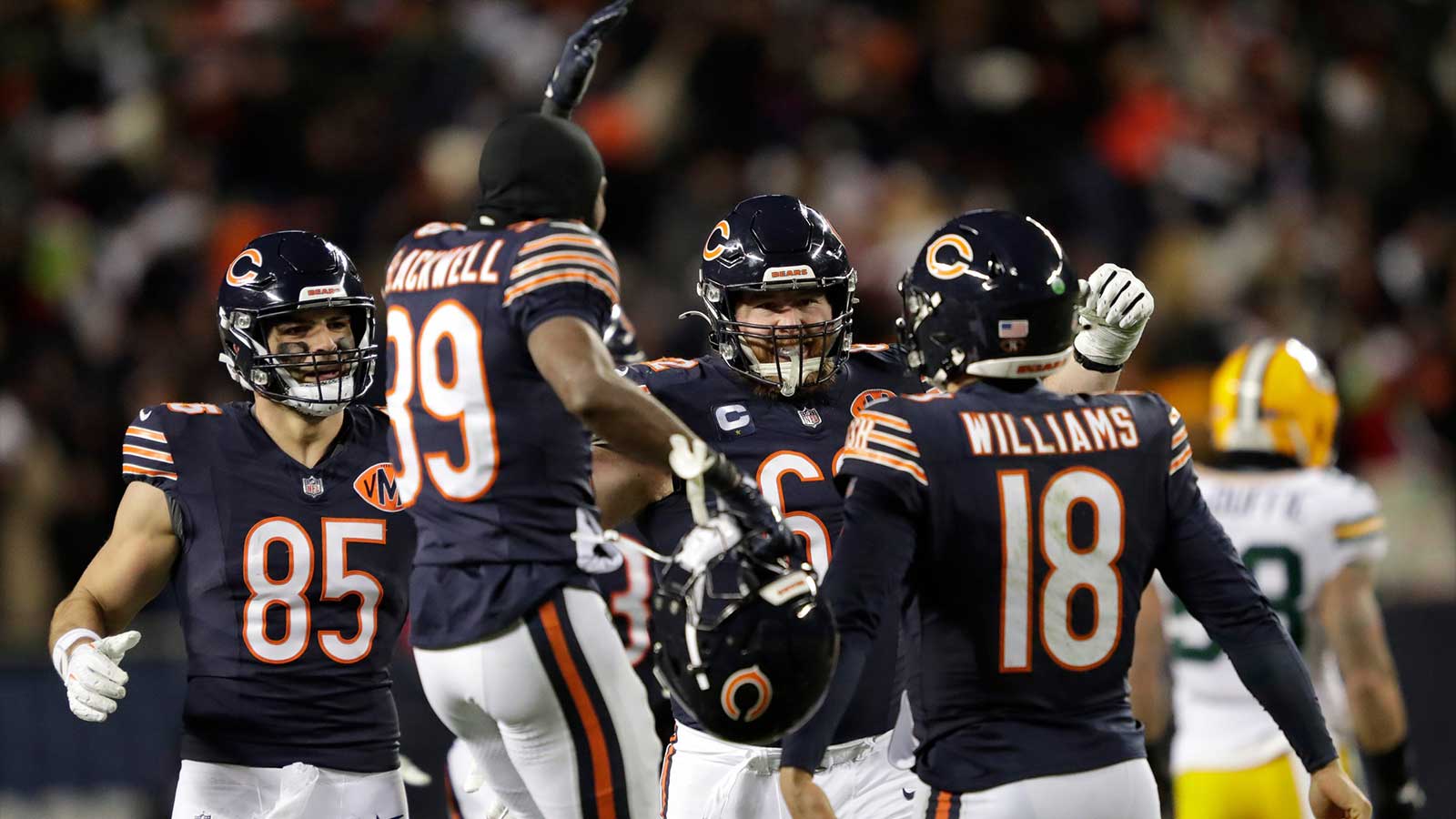 Chicago Bears quarterback Caleb Williams (18) is swarmed by teammates after throwing the game-winning touchdown pass in overtime against the Green Bay Packers during their football game Saturday