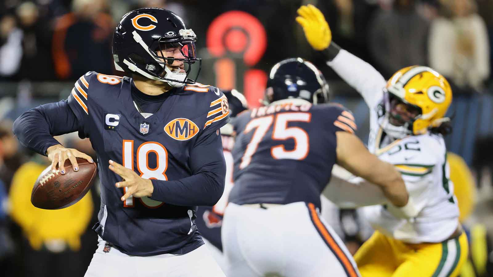 Chicago Bears quarterback Caleb Williams (18) prepares to throw a pass and offensive tackle Ozzy Trapilo (75) blocks against Green Bay Packers defensive end Rashan Gary (52) during the first quarter at Soldier Field.