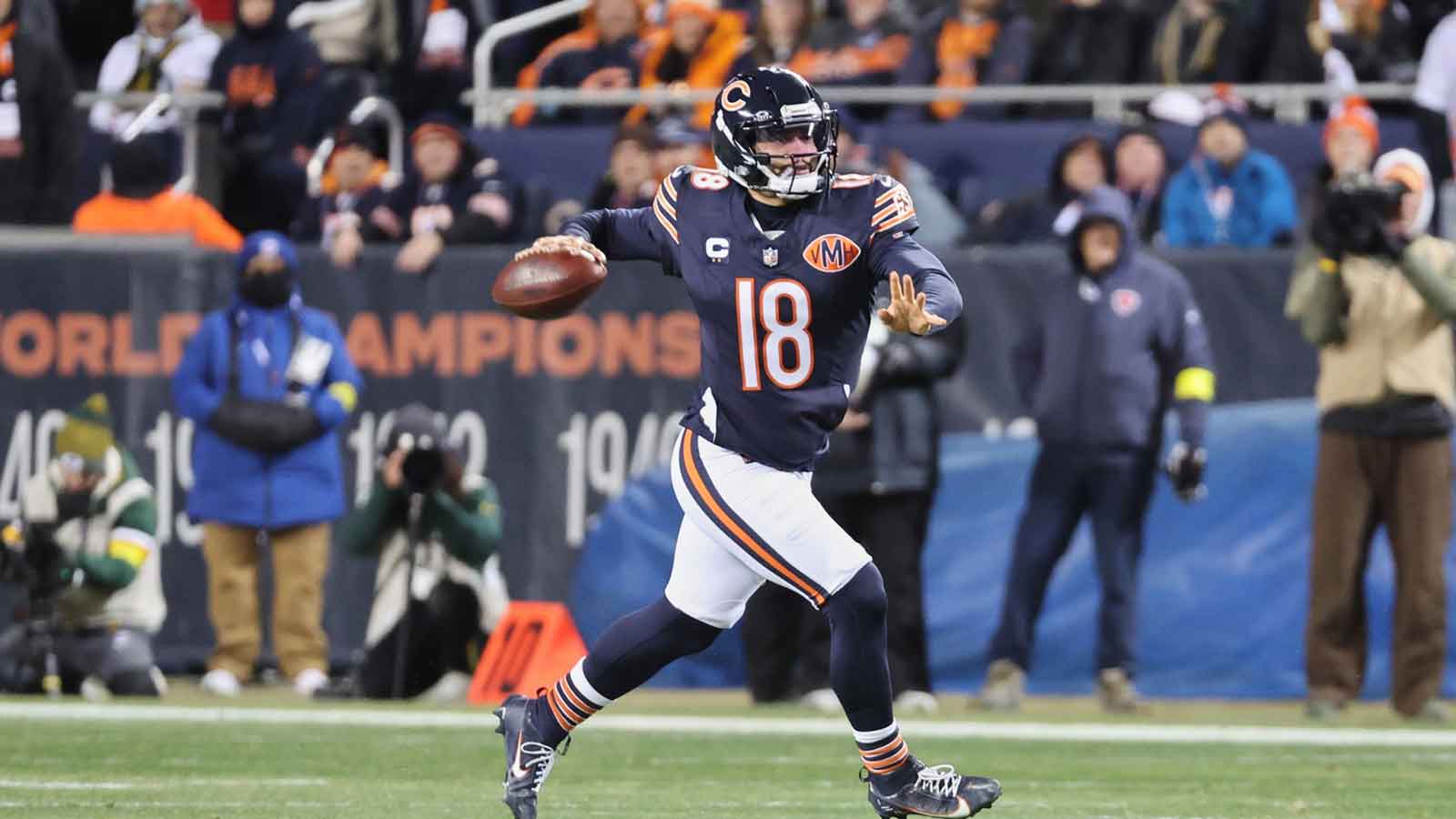 Chicago Bears quarterback Caleb Williams (18) looks to throw a pass while running with the ball against the Green Bay Packers during the first quarter at Soldier Field.
