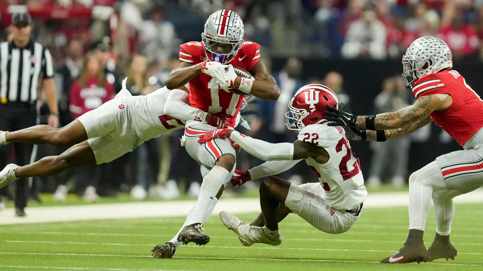 Indiana Hoosiers defensive back Byron Baldwin Jr. (2) and Indiana Hoosiers defensive back Jamari Sharpe (22) bring down Ohio State Buckeyes wide receiver Carnell Tate (17) on Saturday, Dec. 6, 2025, during the Big Ten football championship at Lucas Oil Stadium in Indianapolis.