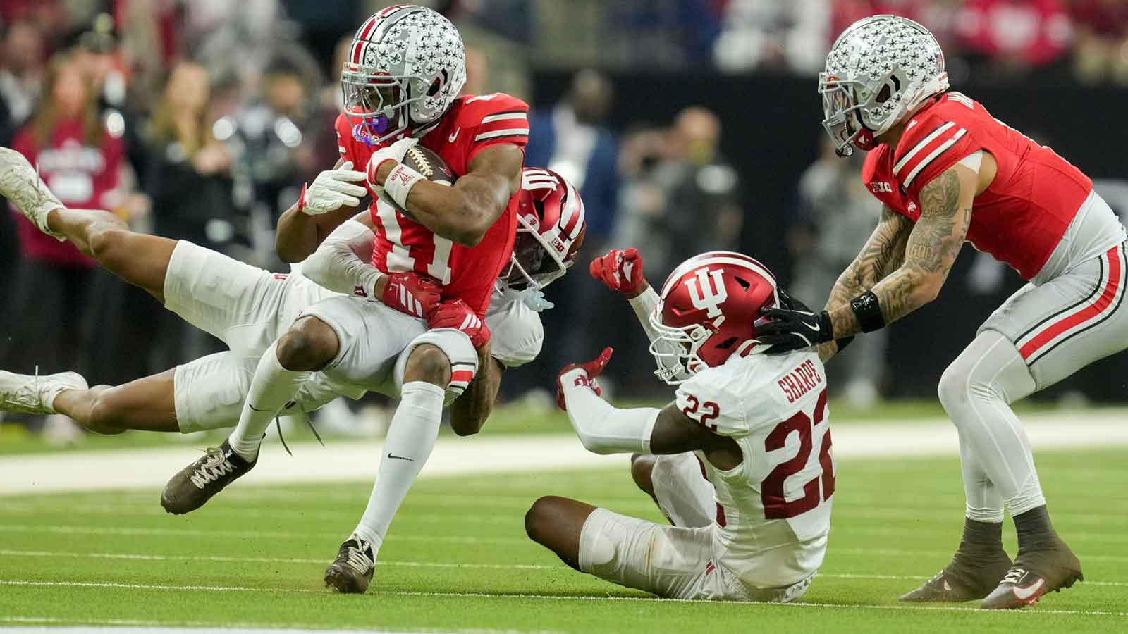 Indiana Hoosiers defensive back Byron Baldwin Jr. (2) and Indiana Hoosiers defensive back Jamari Sharpe (22) bring down Ohio State Buckeyes wide receiver Carnell Tate (17) on Saturday, Dec. 6, 2025, during the Big Ten football championship at Lucas Oil Stadium in Indianapolis.