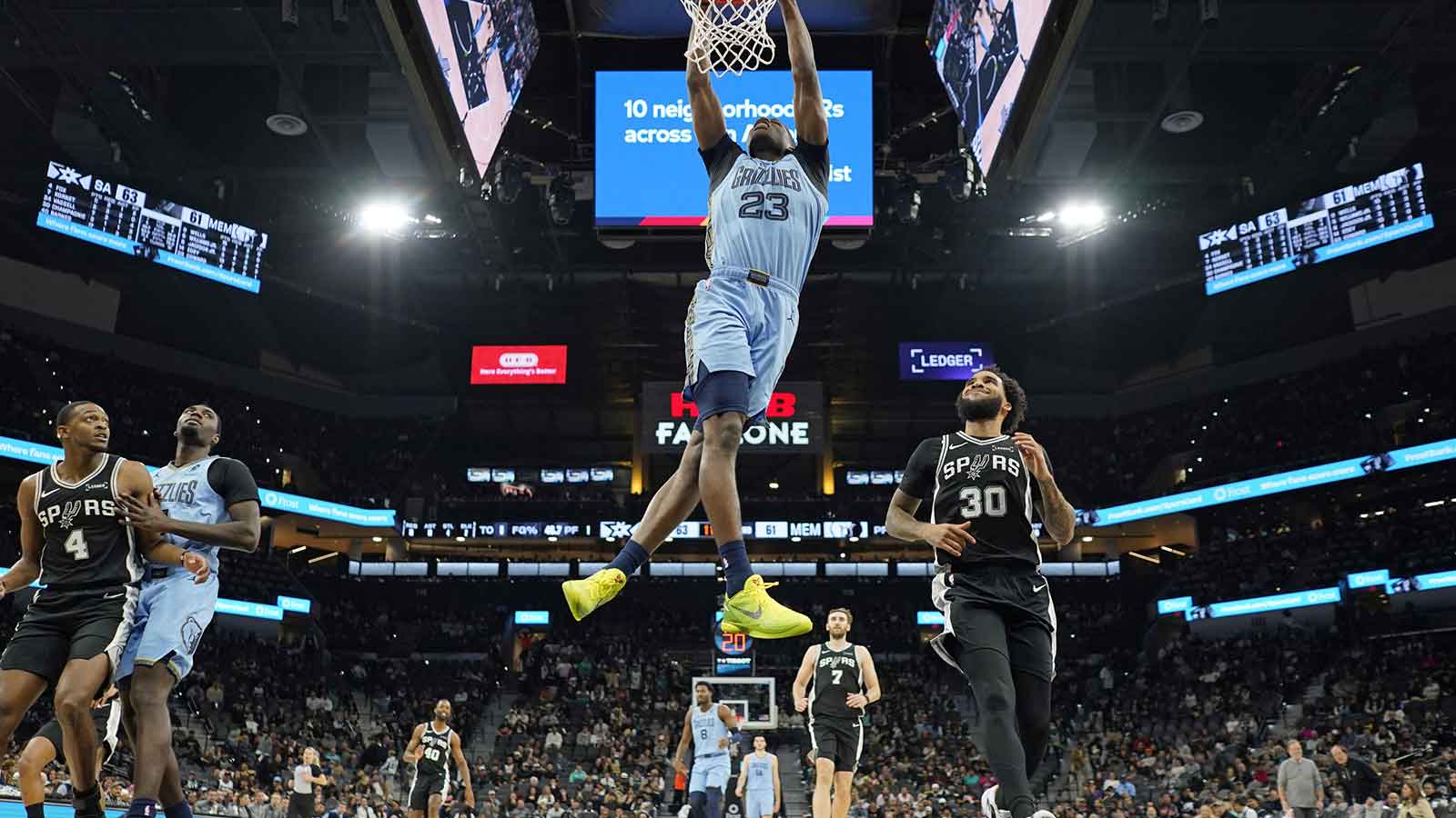 Memphis Grizzlies forward Cedric Coward (23) dunks ahead of San Antonio Spurs forward Julian Champagnie (30) during the second half at Frost Bank Center.