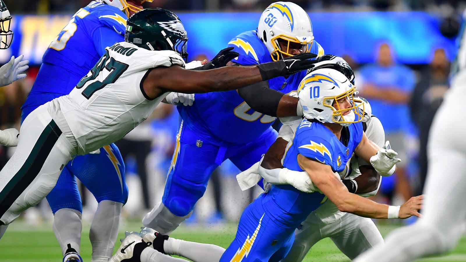 Philadelphia Eagles linebacker Jalyx Hunt (58) tackles Los Angeles Chargers quarterback Justin Herbert (10) in the first half at SoFi Stadium.
