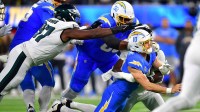 Philadelphia Eagles linebacker Jalyx Hunt (58) tackles Los Angeles Chargers quarterback Justin Herbert (10) in the first half at SoFi Stadium.