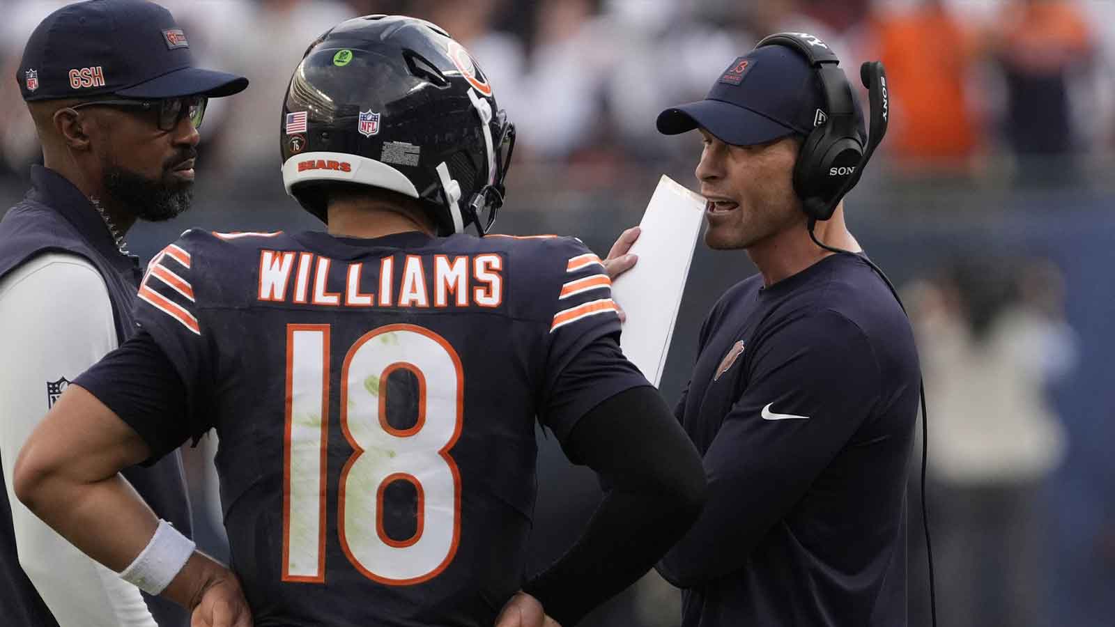 Chicago Bears head coach Ben Johnson talks with quarterback Caleb Williams (18)