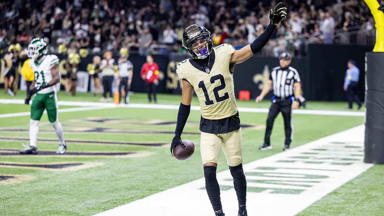 New Orleans Saints wide receiver Chris Olave (12) waves to fans after scoring a touchdown against New York Jets cornerback Brandon Stephens (21) during the second half at Caesars Superdome.