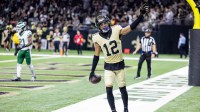 New Orleans Saints wide receiver Chris Olave (12) waves to fans after scoring a touchdown against New York Jets cornerback Brandon Stephens (21) during the second half at Caesars Superdome.
