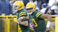 Green Bay Packers quarterback Jordan Love (10) smiles as he runs off the field with wide receiver Christian Watson (9) after the two connected on a touchdown pass against the Los Angeles Chargers at Lambeau Field.