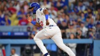 Los Angeles Dodgers catcher Chuckie Robinson (52) runs toward first base after a bunt against the Philadelphia Phillies in the third inning at Dodger Stadium.