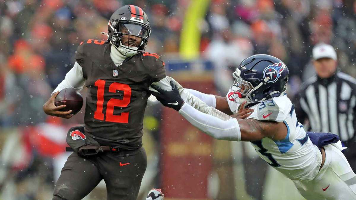Cleveland Browns quarterback Shedeur Sanders (12) picks up a first down on his feet ahead of Tennessee Titans linebacker Cedric Gray (33) during the first half of an NFL football game at Huntington Bank Field, Dec. 7, 2025, in Cleveland, Ohio.