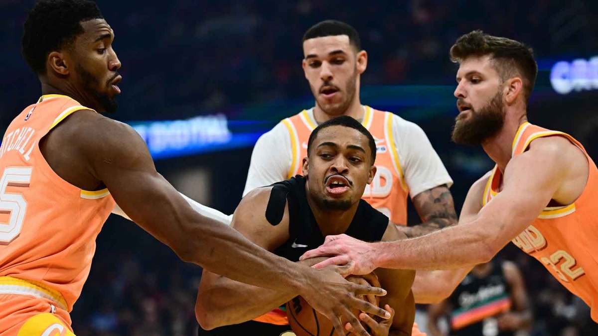 San Antonio Spurs forward Keldon Johnson (3) drives to the basket against Cleveland Cavaliers forward Dean Wade (32) and guard Donovan Mitchell (45) and guard Lonzo Ball (2) during the first half at Rocket Arena.