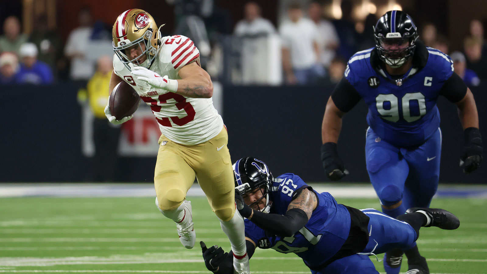 San Francisco 49ers running back Christian McCaffrey (23) avoids a tackle by Indianapolis Colts defensive end Laiatu Latu (97) in the second quarter of the game at Lucas Oil Stadium. 