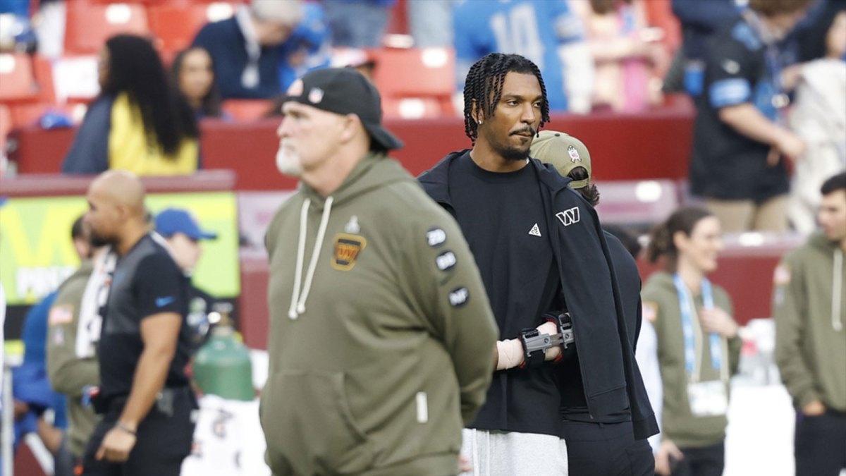 Washington Commanders head coach Dan Quinn stands with quarterback Jayden Daniels (5) on the sidelines during warmups prior to a game against the Detroit Lions at Northwest Stadium.