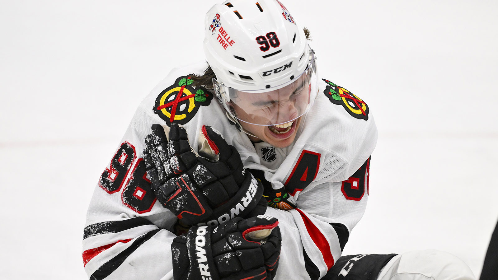 Chicago Blackhawks center Connor Bedard (98) reacts in pain after a face off against St. Louis Blues center Brayden Schenn (not pictured) during the third period at Enterprise Center.
