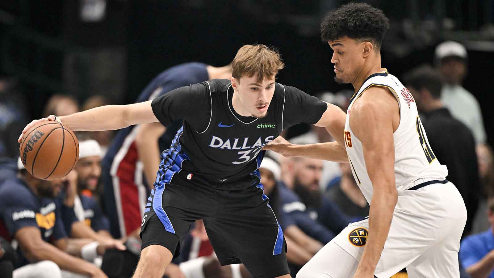 Dallas Mavericks forward Cooper Flagg (32) looks to move the ball past Denver Nuggets forward Spencer Jones (21) during the first quarter at the American Airlines Center.