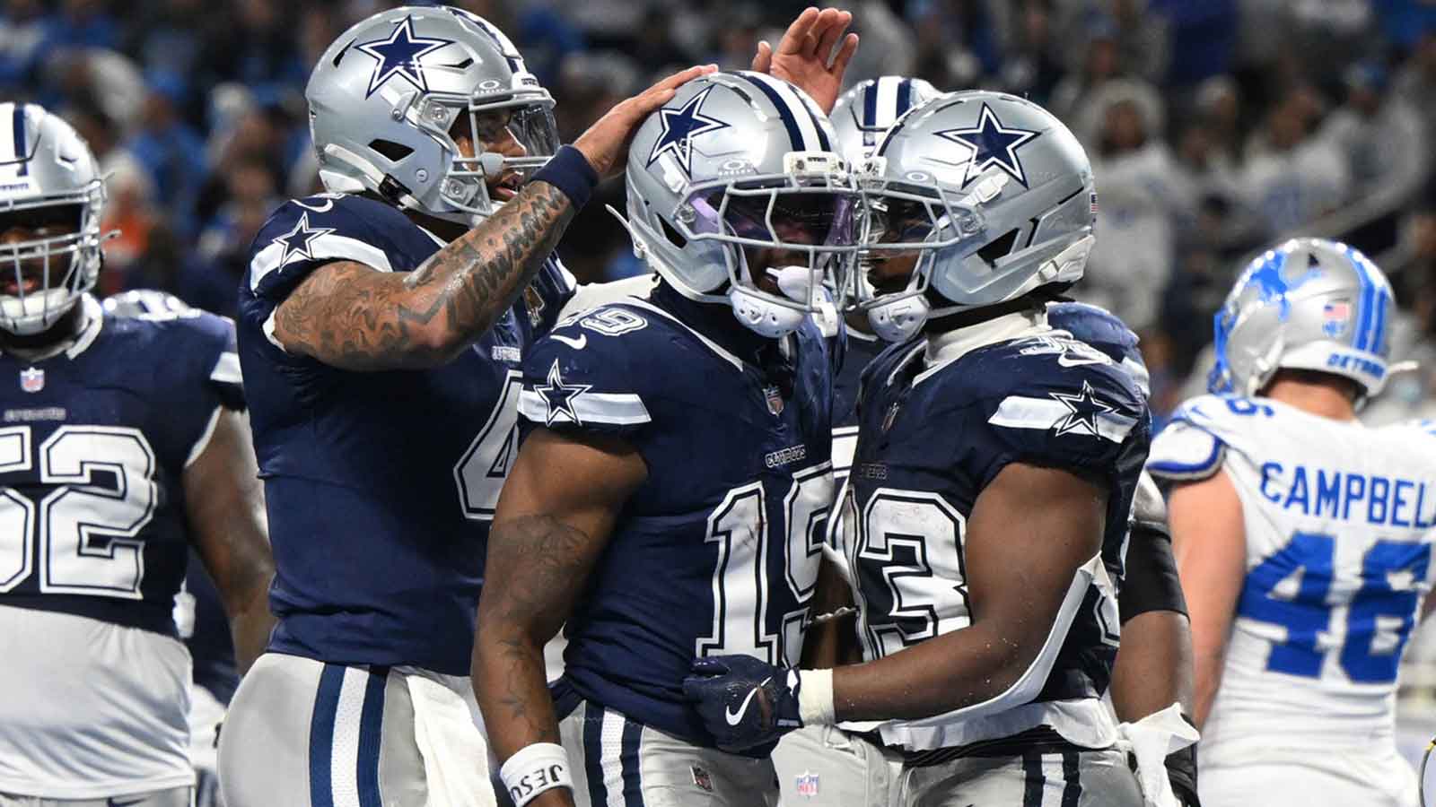Dallas Cowboys running back Javonte Williams (33) celebrates with quarterback Dak Prescott (4) and wide receiver Ryan Flournoy (19) after scoring a touchdown during the second half against the Detroit Lions at Ford Field.
