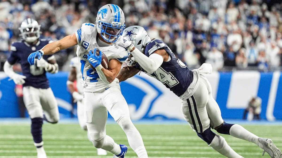 Detroit Lions wide receiver Amon-Ra St. Brown (14) makes a catch against Dallas Cowboys cornerback Shavon Revel Jr. (34) during the second half at Ford Field in Detroit on Thursday, Dec. 4, 2025.