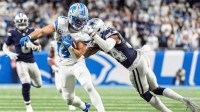 Detroit Lions wide receiver Amon-Ra St. Brown (14) makes a catch against Dallas Cowboys cornerback Shavon Revel Jr. (34) during the second half at Ford Field in Detroit on Thursday, Dec. 4, 2025.