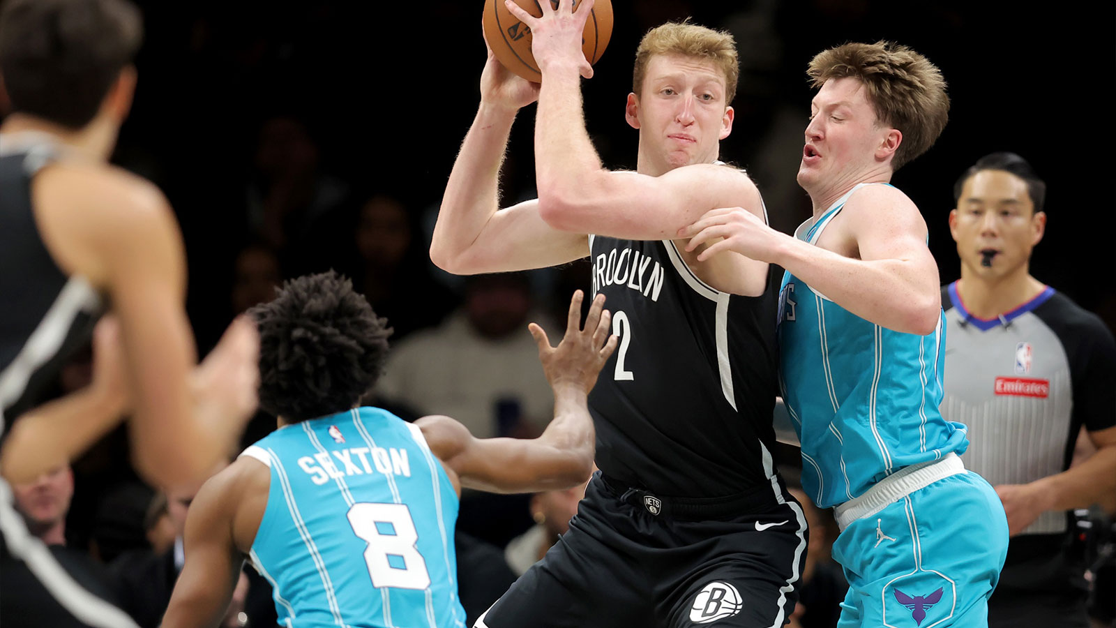 Brooklyn Nets forward Danny Wolf (2) looks to pass the ball against Charlotte Hornets guards Kon Knueppel (7) and Collin Sexton (8) during the first quarter at Barclays Center.