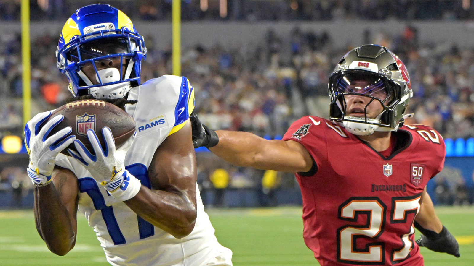 Los Angeles Rams wide receiver Davante Adams (17) catches a touchdown pass as he is defended by Tampa Bay Buccaneers cornerback Zyon McCollum (27) during the first half at SoFi Stadium.