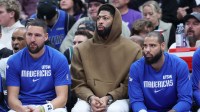 Dallas Mavericks forward Anthony Davis (center) watches the game against the Utah Jazz in street clothes with guard Klay Thompson (left) and forward Caleb Martin (right) during the second half at Delta Center