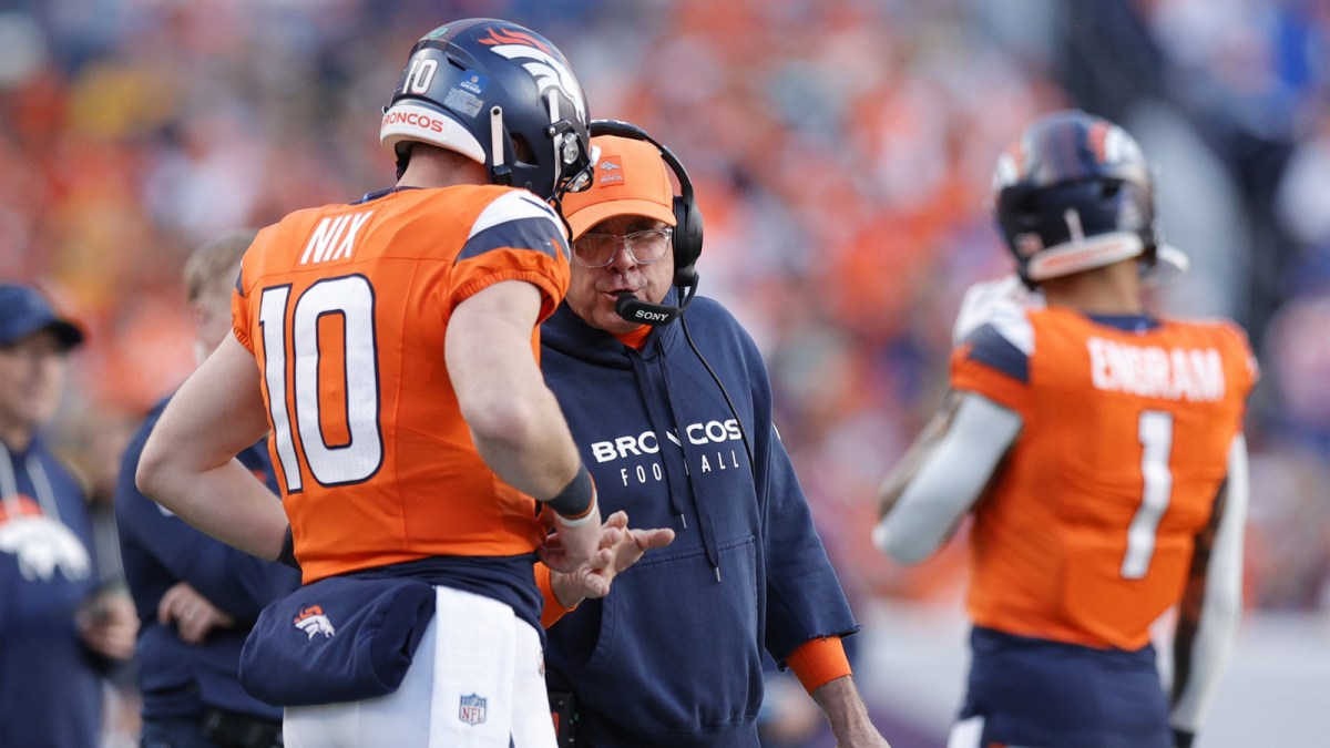 Denver Broncos head coach Sean Payton talks with quarterback Bo Nix (10) during the second quarter against the Green Bay Packers at Empower Field at Mile High.