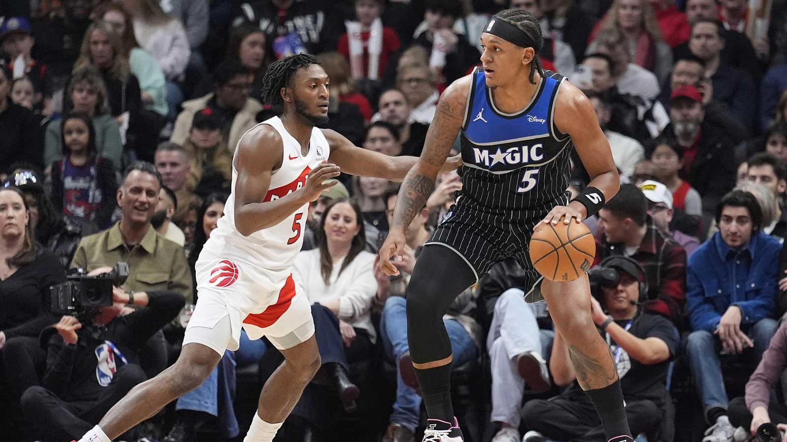 Orlando Magic forward Paolo Banchero (5) controls the ball against Toronto Raptors guard Immanuel Quickley (5) during the first half at Scotiabank Arena.
