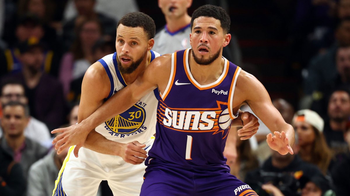 Phoenix Suns guard Devin Booker (1) against Golden State Warriors guard Stephen Curry (30) in the first half at Mortgage Matchup Center.
