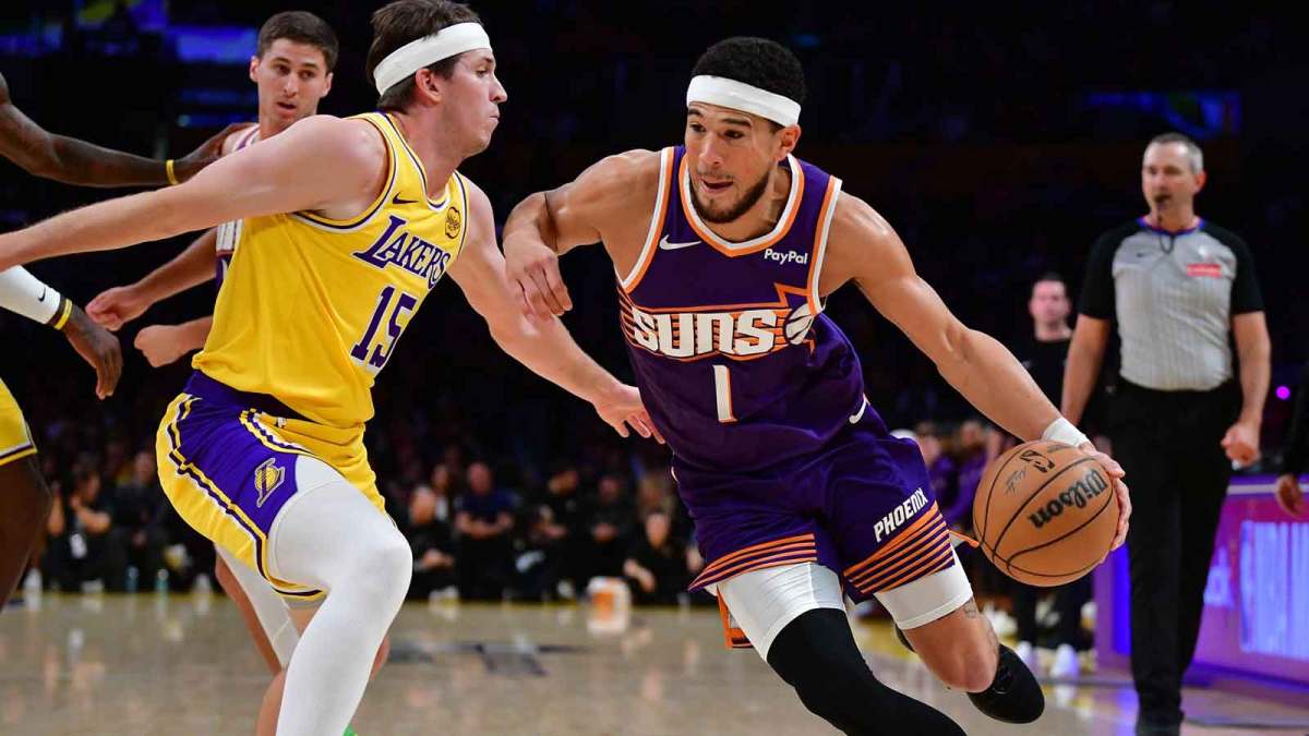 Phoenix Suns guard Devin Booker (1) moves the ball against Los Angeles Lakers guard Austin Reaves (15) during the first half at Crypto.com Arena.