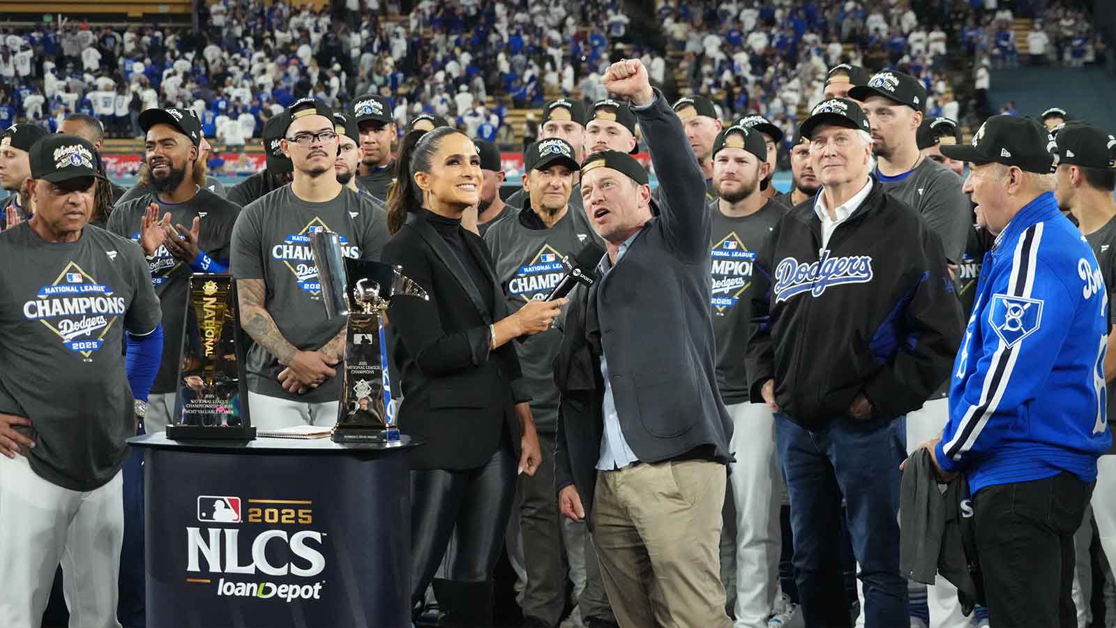 Los Angeles Dodgers president of baseball operations Andrew Friedman is interviewed by TBS reporter Lauren Shehadi as owner Mark Walter and president Stan Kasten watch after game four of the NLCS round for the 2025 MLB playoffs against the Milwaukee Brewers at Dodger Stadium.