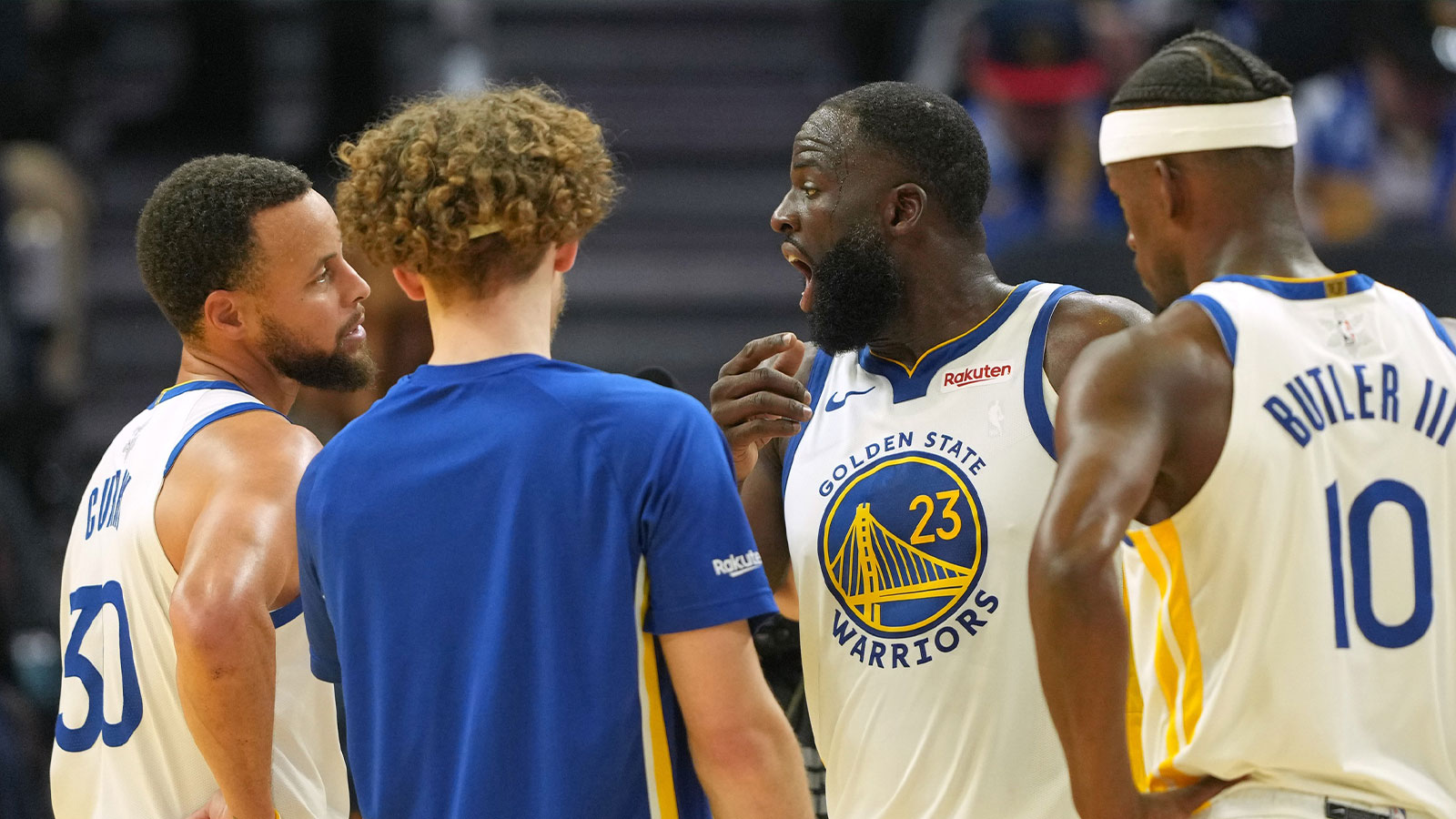Golden State Warriors forward Draymond Green (23) talks with guard Stephen Curry (30) with guard Brandin Podziemski (center left) and forward Jimmy Butler III (10) during the third quarter against the Dallas Mavericks at Chase Center.