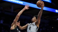 San Antonio Spurs guard Dylan Harper (2) shoots the ball as Minnesota Timberwolves center Rudy Gobert (27) defends during the first half at Target Center.